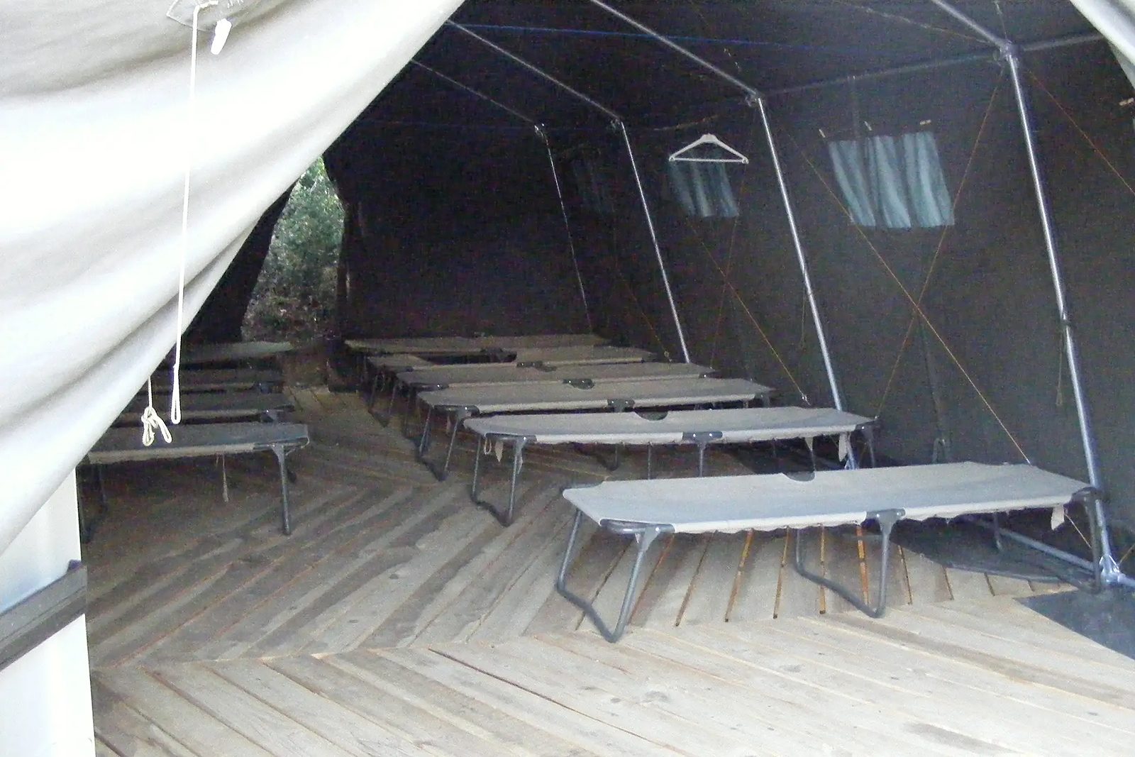 Les lits pliants sous la tente
