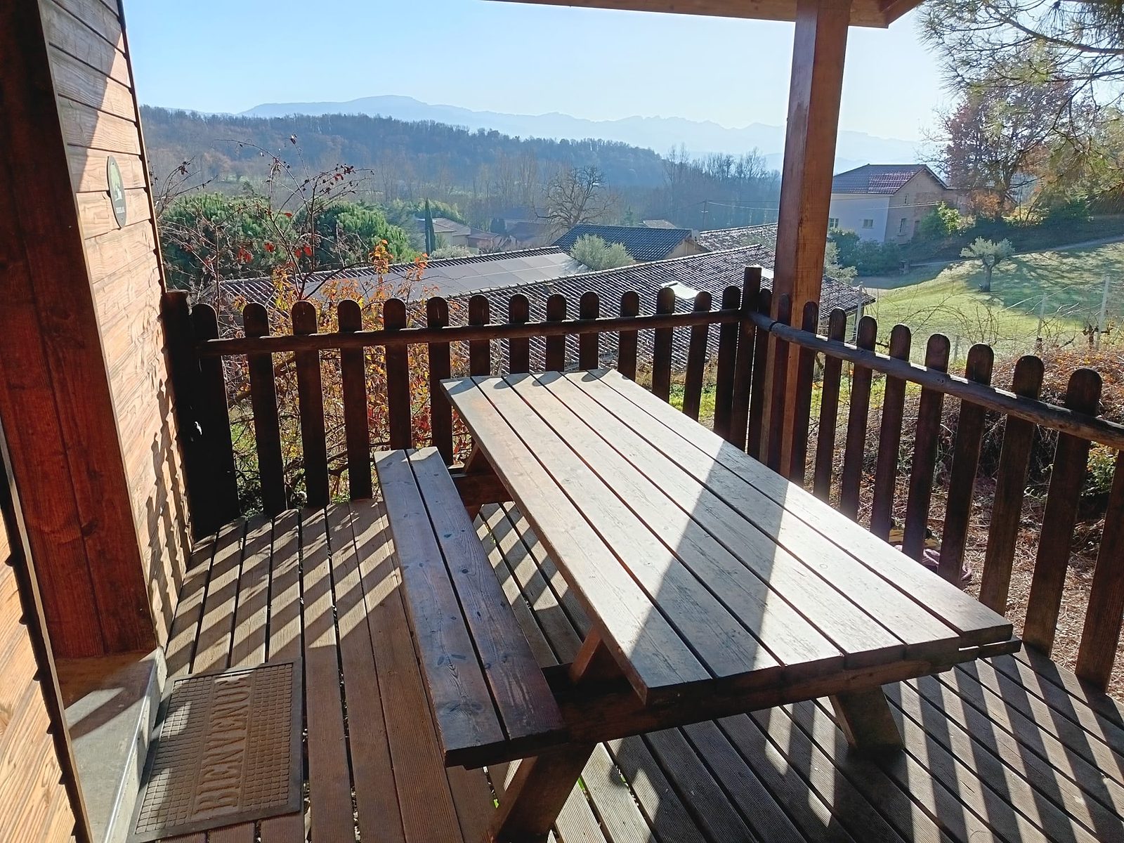 La terrasse en bois du Truffier, sa table et la vue sur les collines et le Vercors