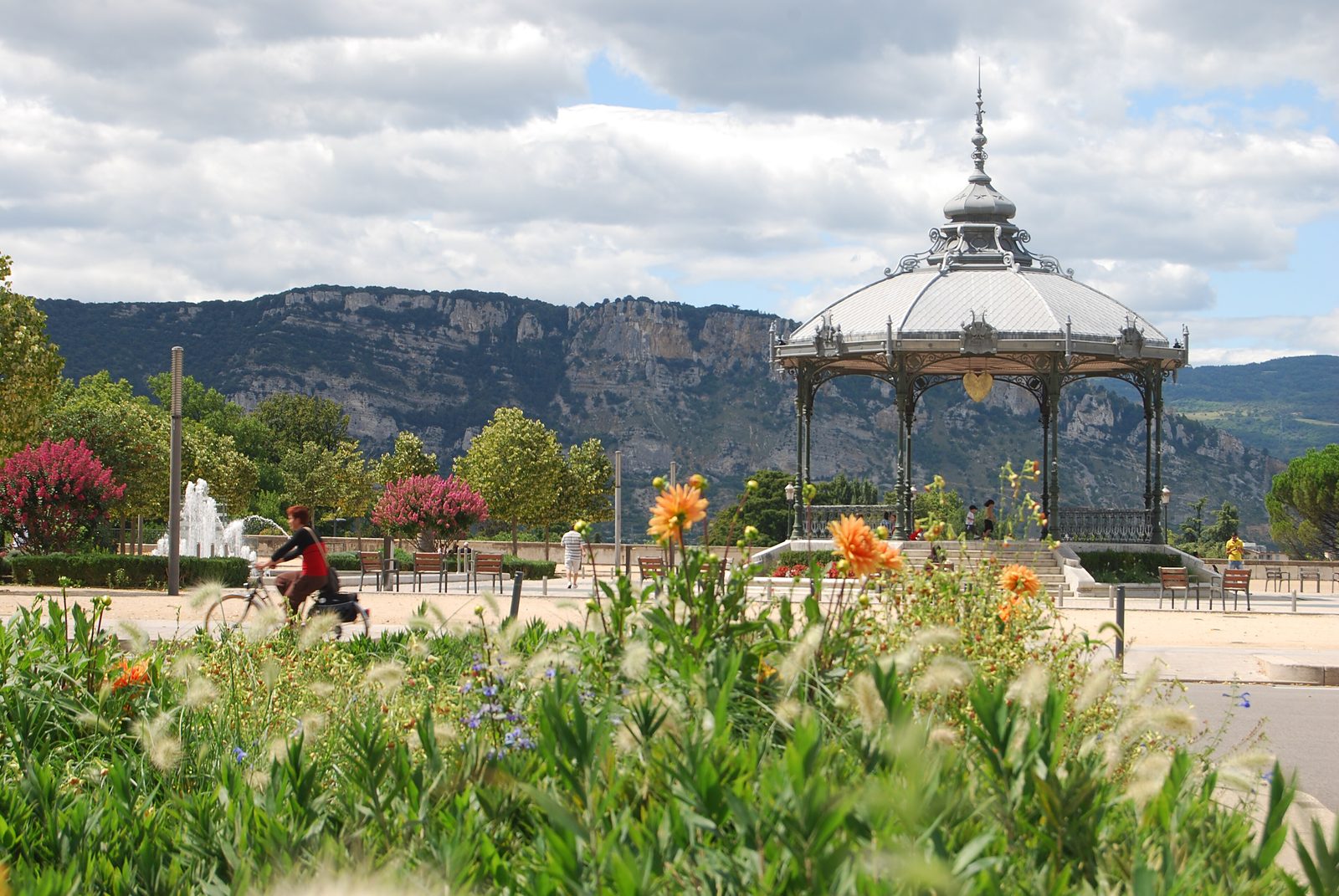 Le kiosque Peynet de Valence entouré de fleurs, avec les montagnes au fond