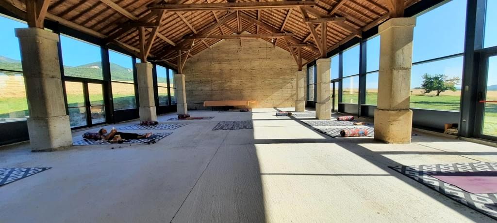 La salle vide, baies ouvertes sur la campagne