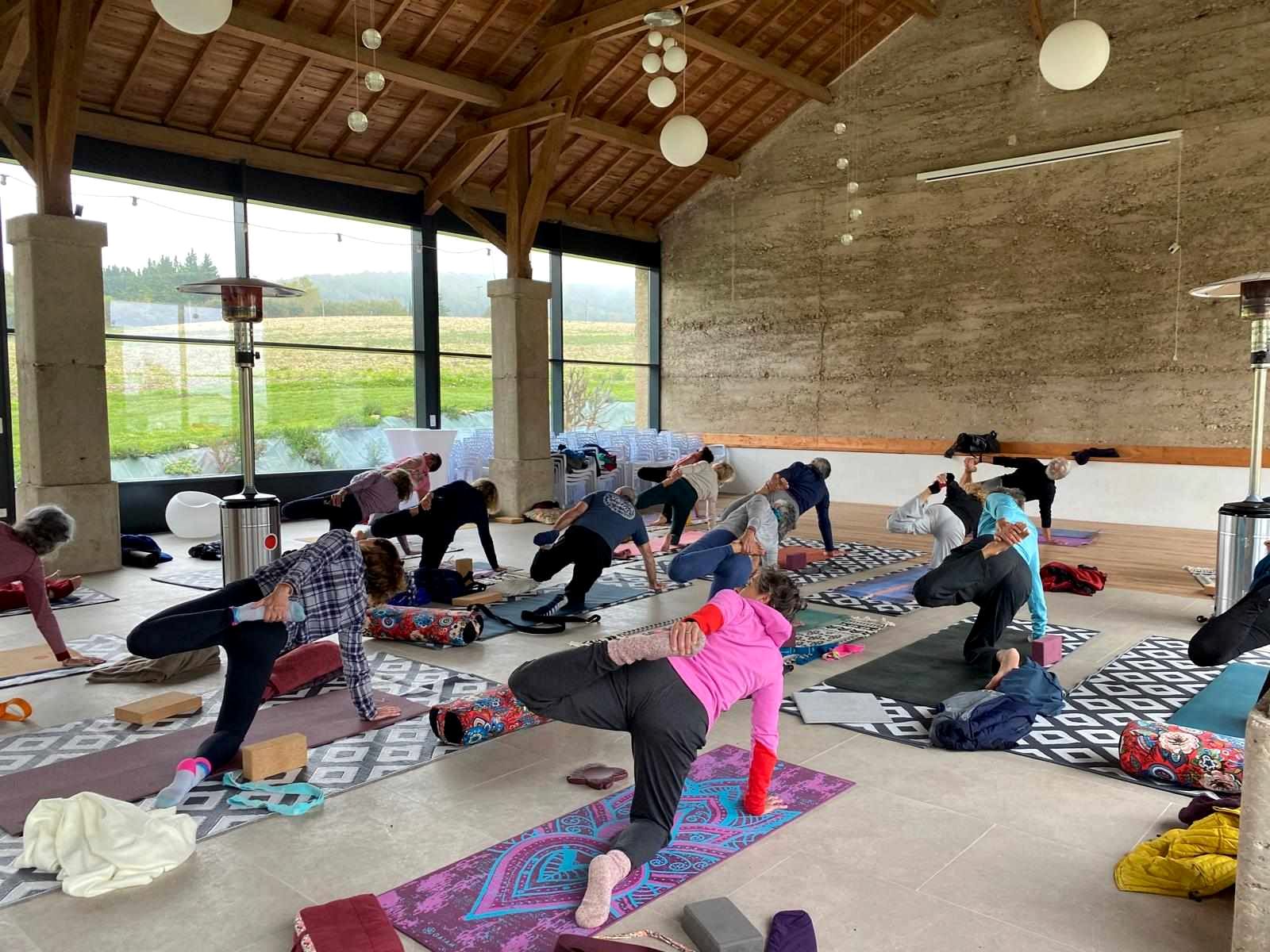 Un cours de yoga dans la salle, baies ouvertes