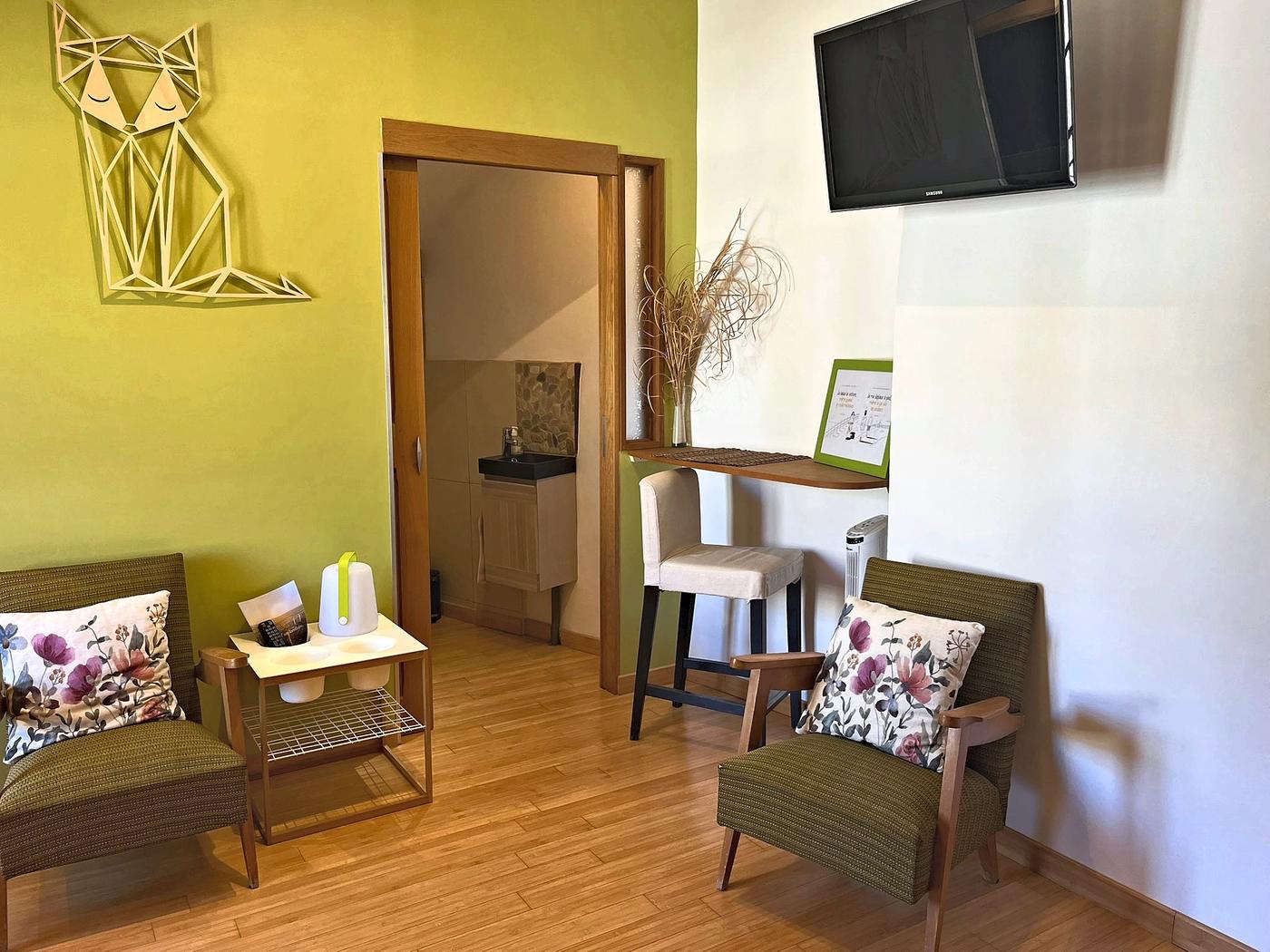 Le coin salon d’En Messepierre, deux fauteuils et la télévision
