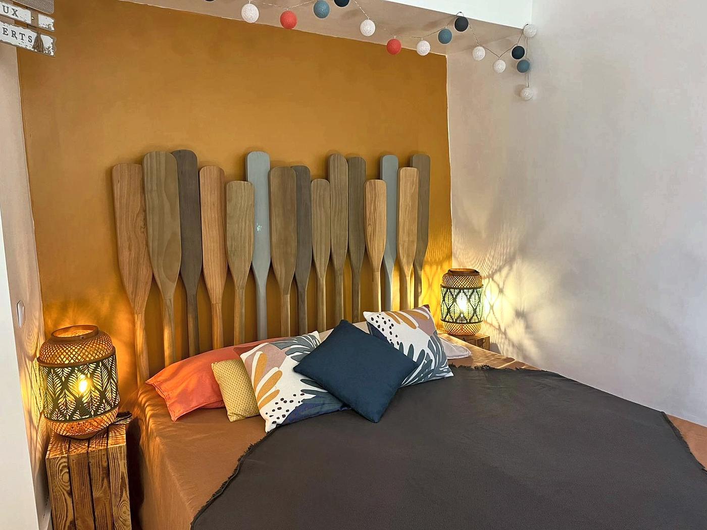 La chambre La Mercantine et sa tête de lit faite de rames de bois