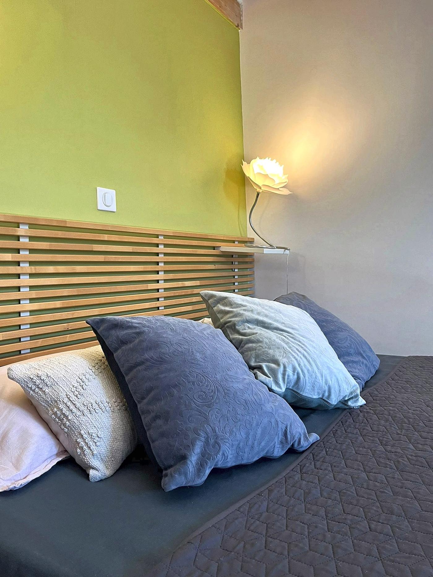 Le lit des Terrasses et sa tête de lit en lattes de bois