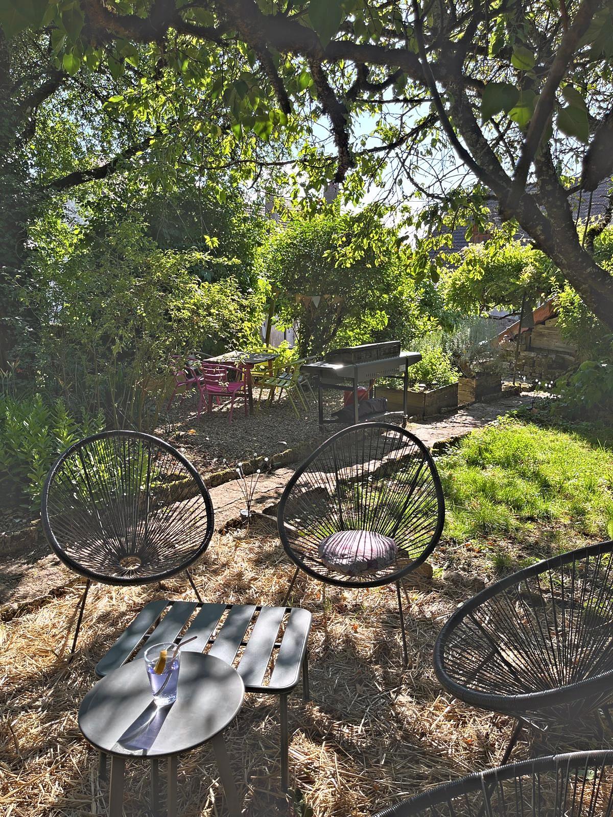 La table et les sièges à l’ombre, au fond du jardin