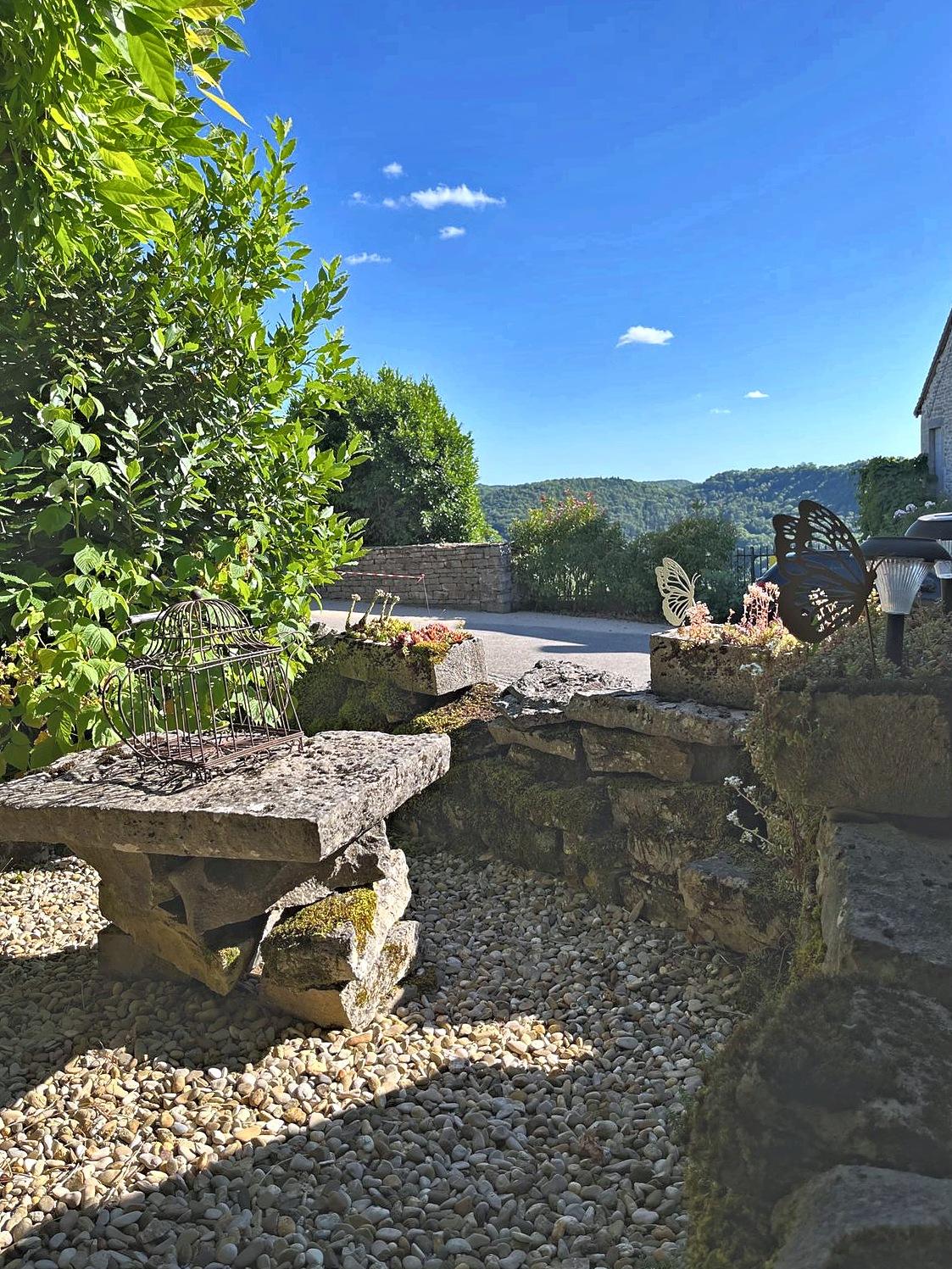 La table en pierre du jardin et la vue sur la reculée de Baume-les-Messieurs