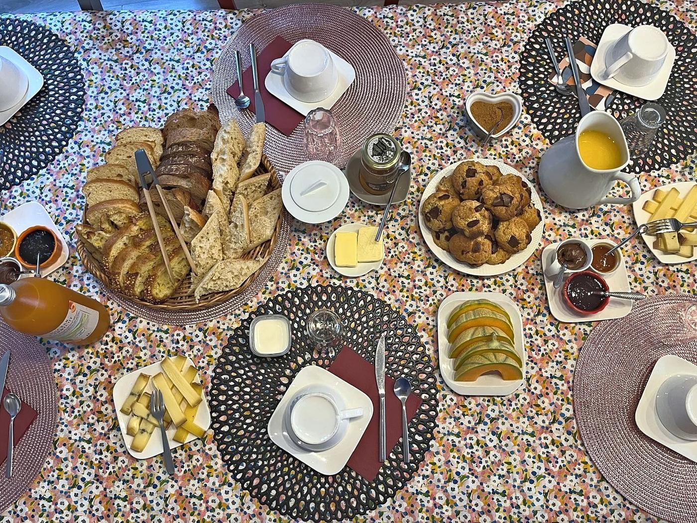 La table du petit déjeuner : viennoiseries, confitures et fruits frais