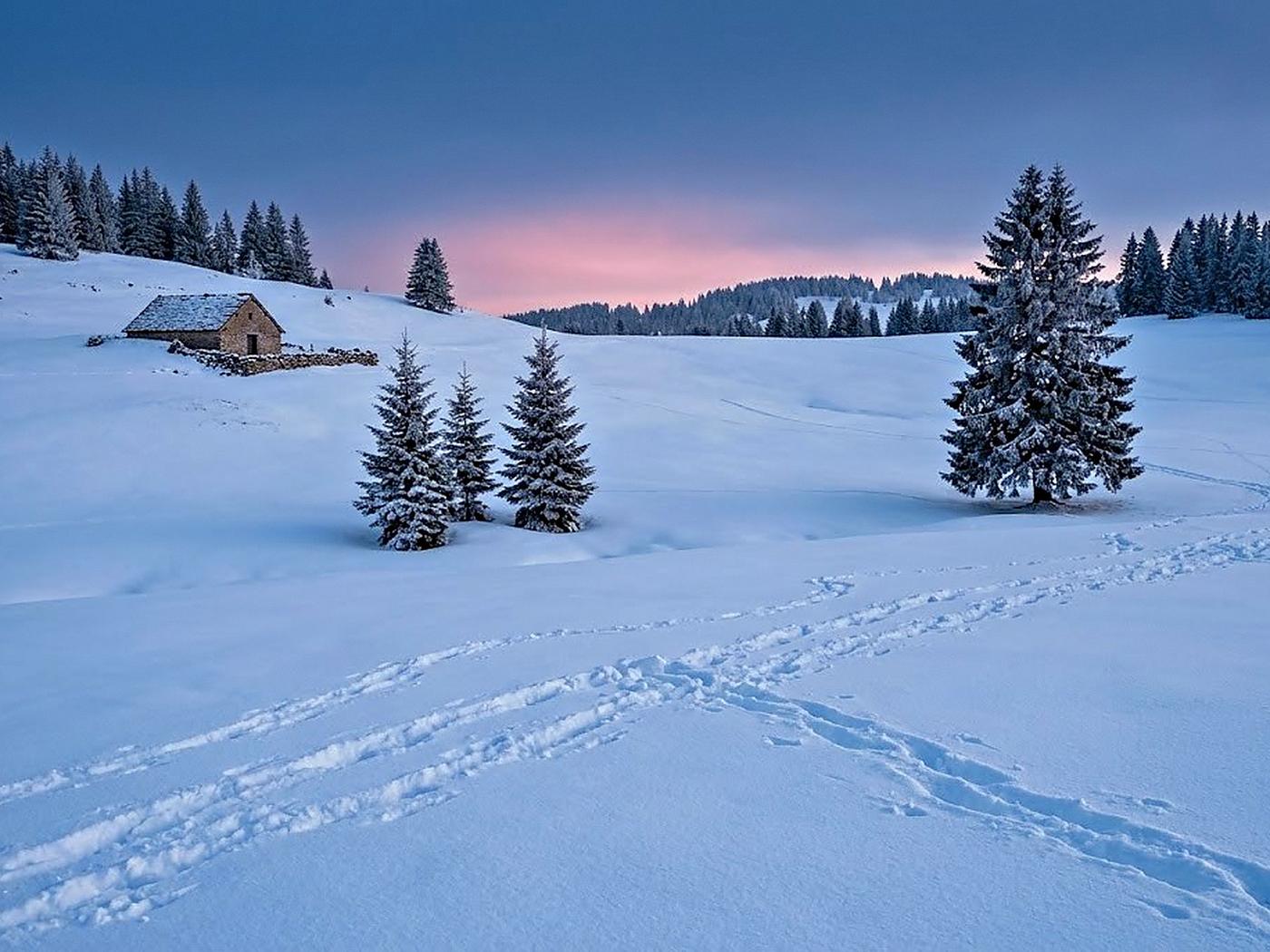 Un plateau du Haut-Jura sous la neige au crépuscule, une ferme isolée et des sapins