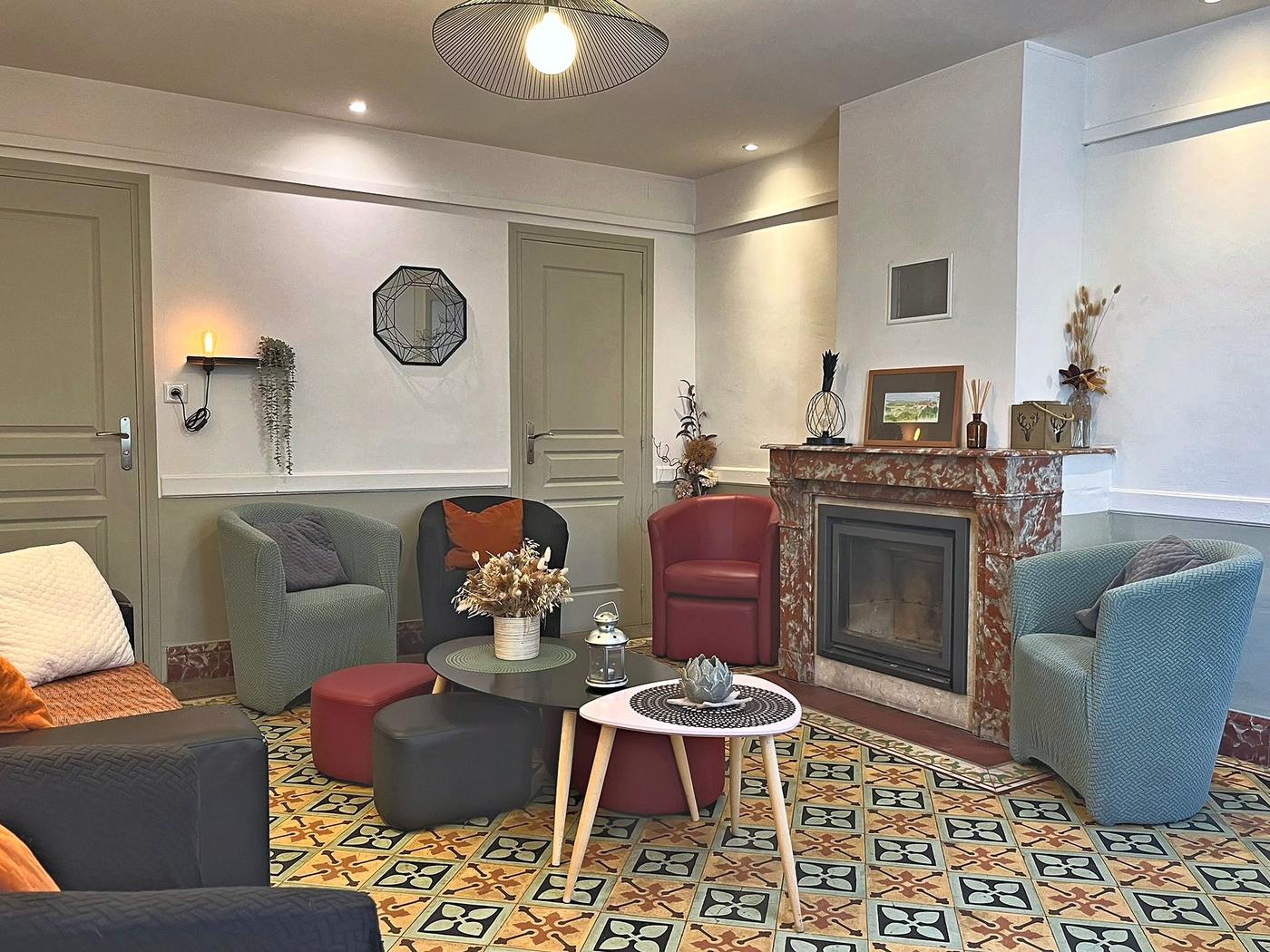 Le salon : fauteuils, cheminée de marbre et sols en carreaux de ciment d’époque